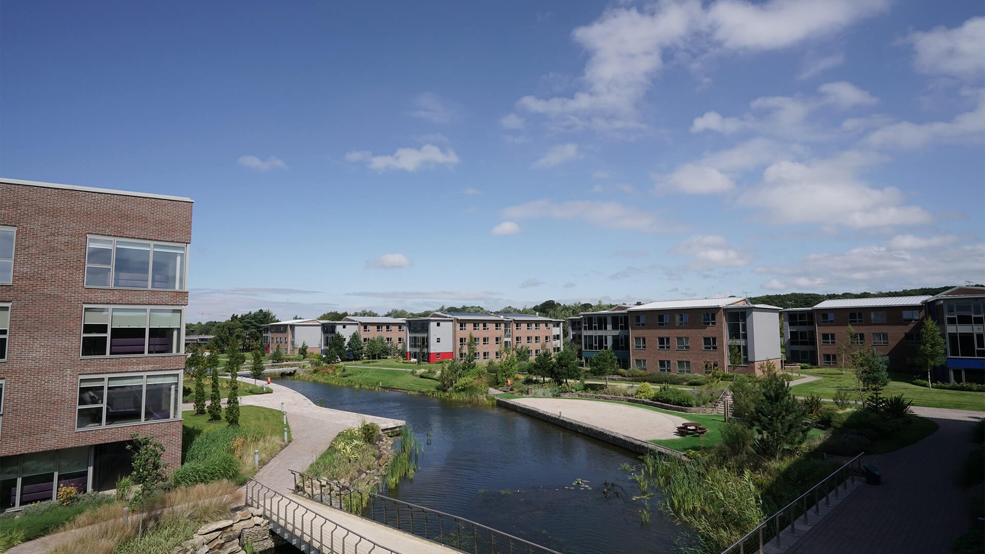 An aerial image of part of Edge Hill Universities' campus. This image focuses on part of the lake running through the campus and some of the accomodation blocks.
