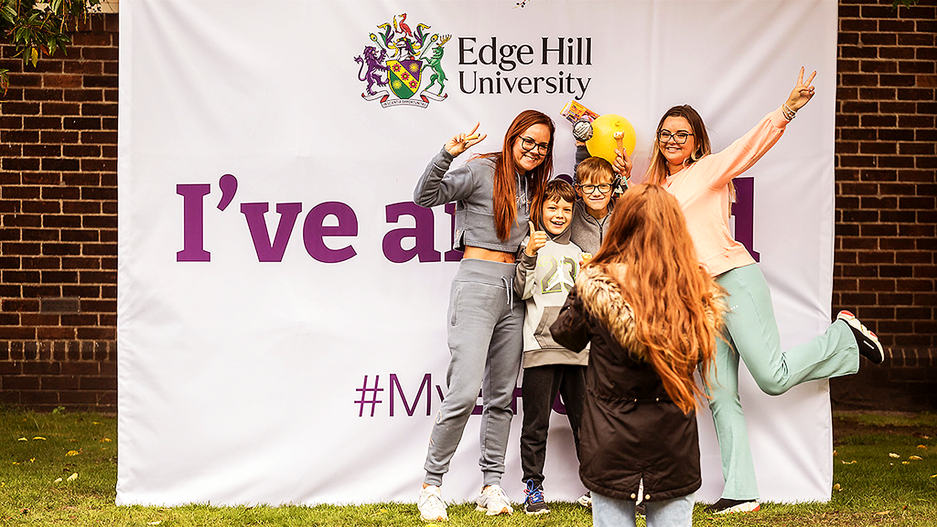 Students and children pose in front of the EHU 'I've arrived' sign on Welcome Sunday.