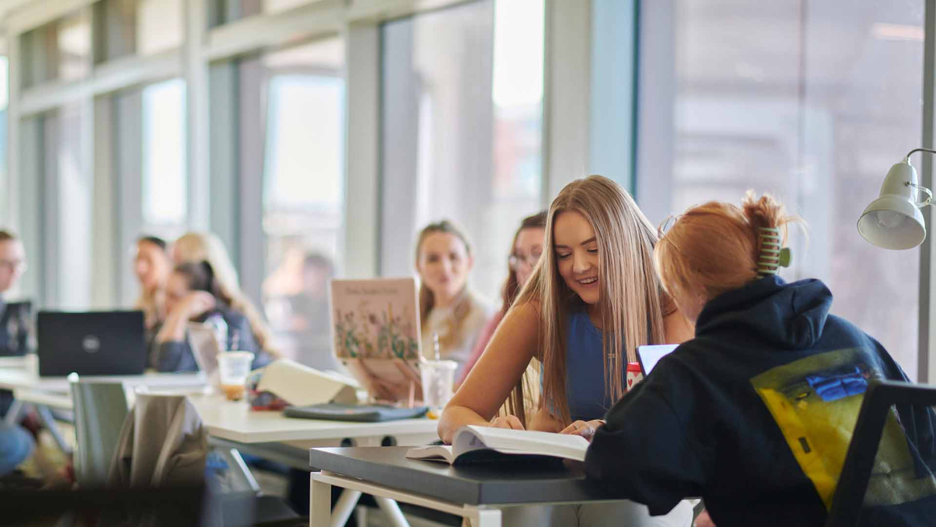 Image of students laughing in Catalyst and reading textbooks together