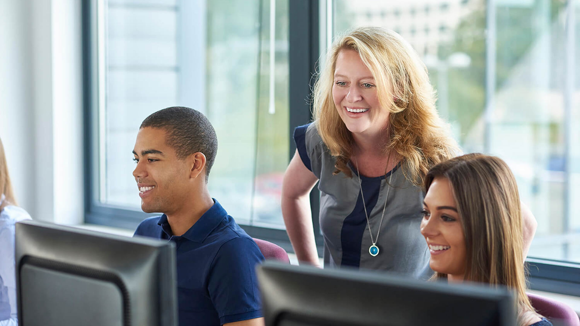 Teacher supporting secondary school students in application process.