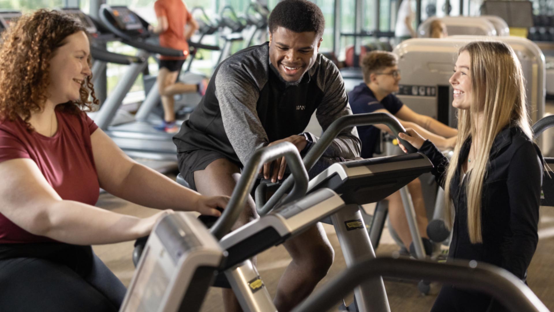 students on spin bikes within a gym